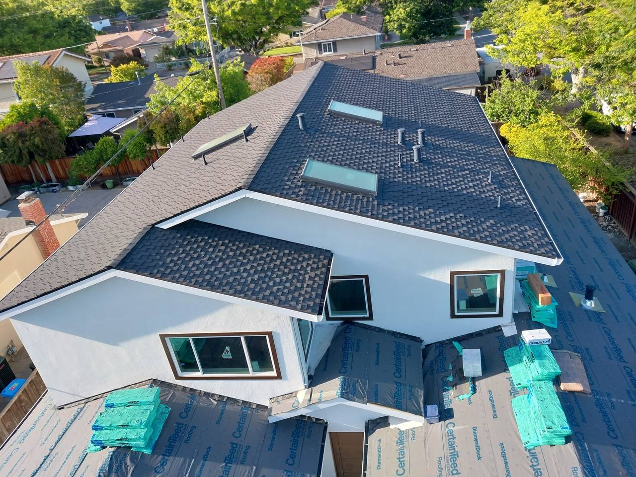 Aerial detail of finished Charcoal roof planes meeting at the ridge with skylight and vent flashing